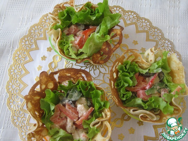 Salad with chicken and tomatoes in fishnet pancakes