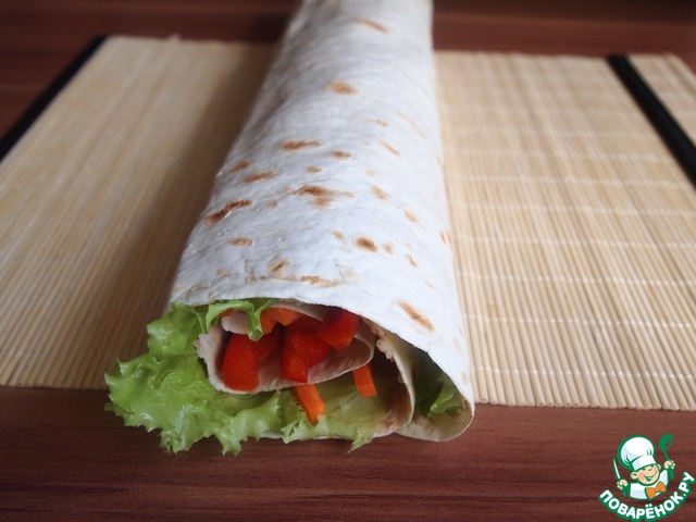 Roll of pita bread with a bean paste and vegetables