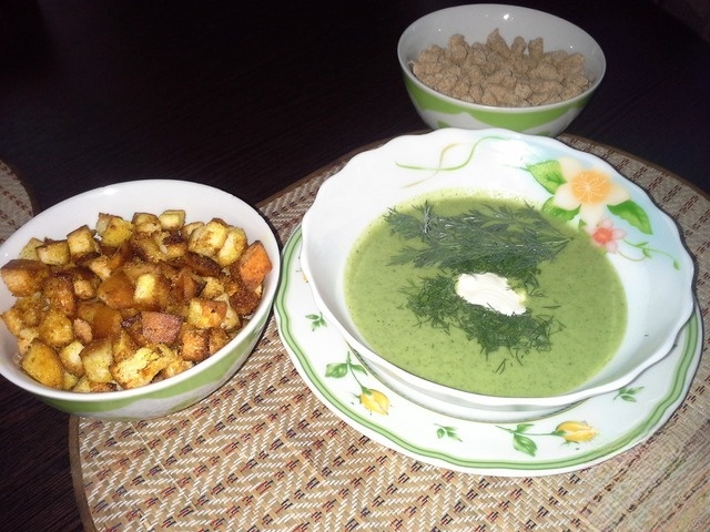 Green soup of broccoli with croutons sun
