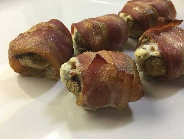 Mushrooms with melted cheese wrapped in bacon