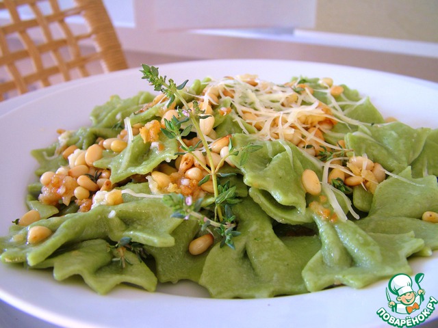 Homemade green Farfalle with roasted garlic and pine nuts