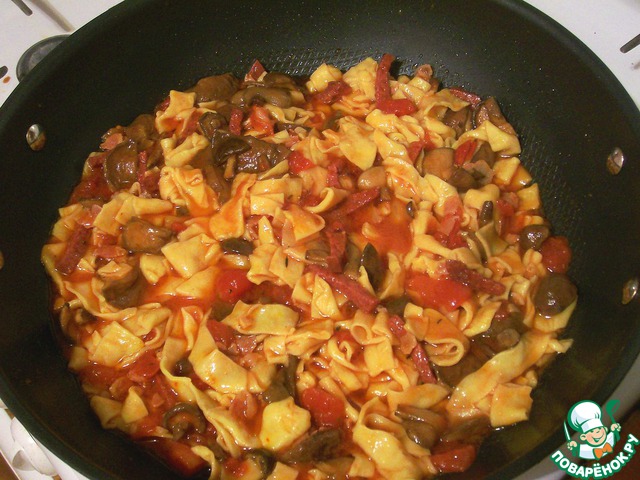 Homemade pasta with mushrooms and bacon in tomato sauce