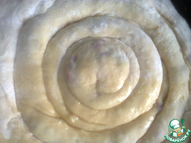 A yeast cake in a spiral with a cherry