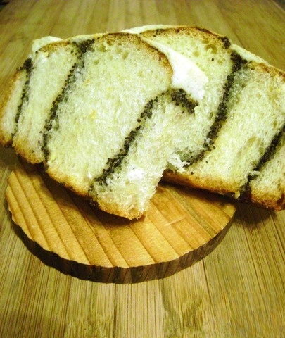 Rolls of orange dough with poppy seeds