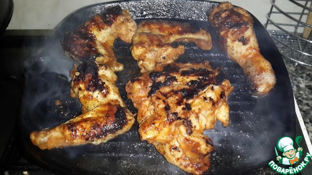 The chicken parts in the marinade grill