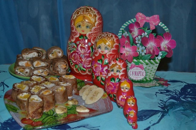 Rolls of pancakes with banana and orange