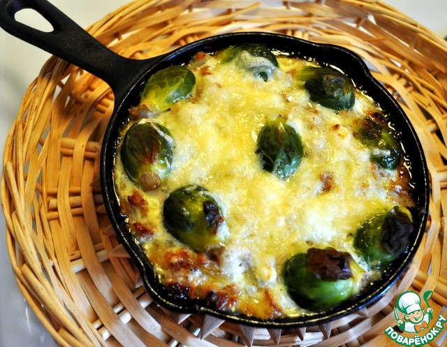 Frying pan with meat casserole and Brussels sprouts in creamy cheese sauce