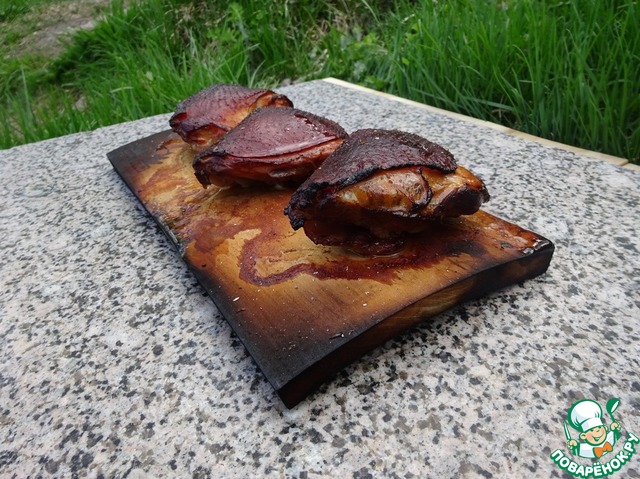 Chicken thighs baked on a grill Board