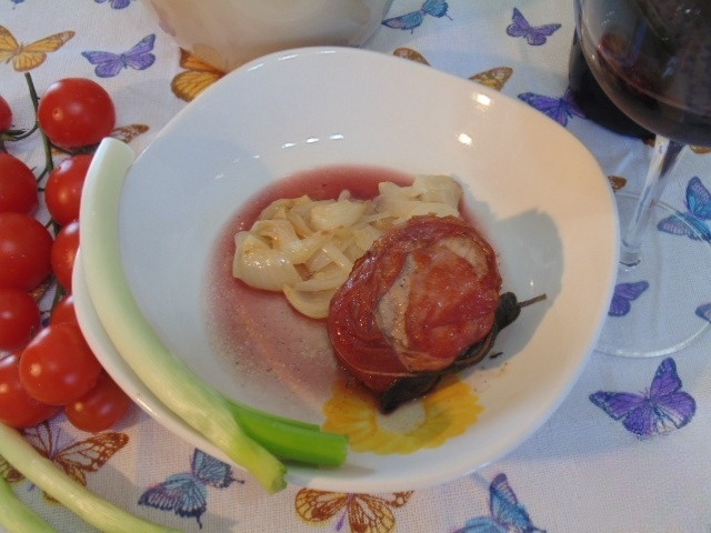 Pork fillet wrapped in bacon with fresh onions